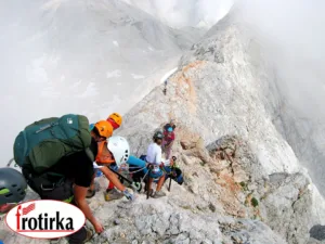 Алпинисти со заштитна опрема се движат по остар карпест гребен на Триглав, дел од експедицијата Трилогија Алпи со поддршка од Фротирка.