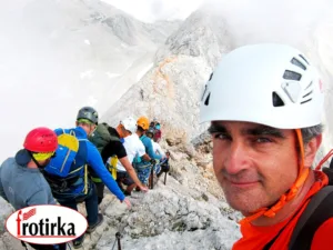 Алпинисти со кациги и сигурносна опрема на остар гребен на Триглав, Јулиски Алпи – експедиција Трилогија Алпи со Фротирка.