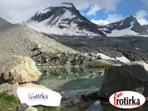 Поглед кон врвот Гранд Парадизо 4061 м.н.в. во Грејски Алпи со планинско езеро и бел пешкир со логото на Фротирка.