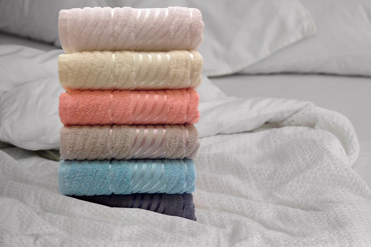 Нови пешкири во повеќе бои наредени на кревет – меки и квалитетни крпи за секојдневна употреба од Frotirka.